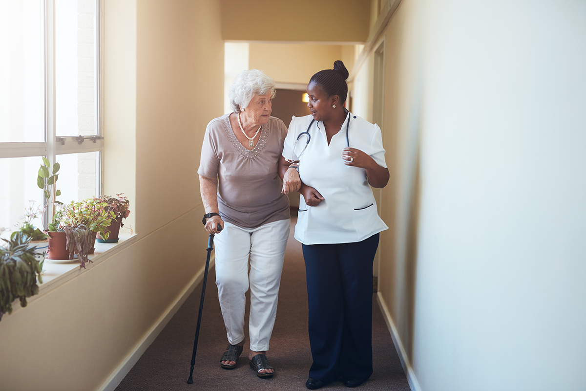 Older woman walking with doctor